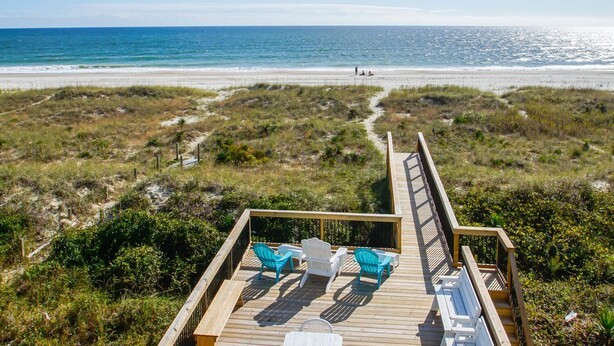 A wooden deck with outdoor seating and a view of the beach. - "Sandy Dunes" - Oceanfront Home w/ Private Pool, 8 Bedrooms / 6.5 Bathrooms (Holden Beach)