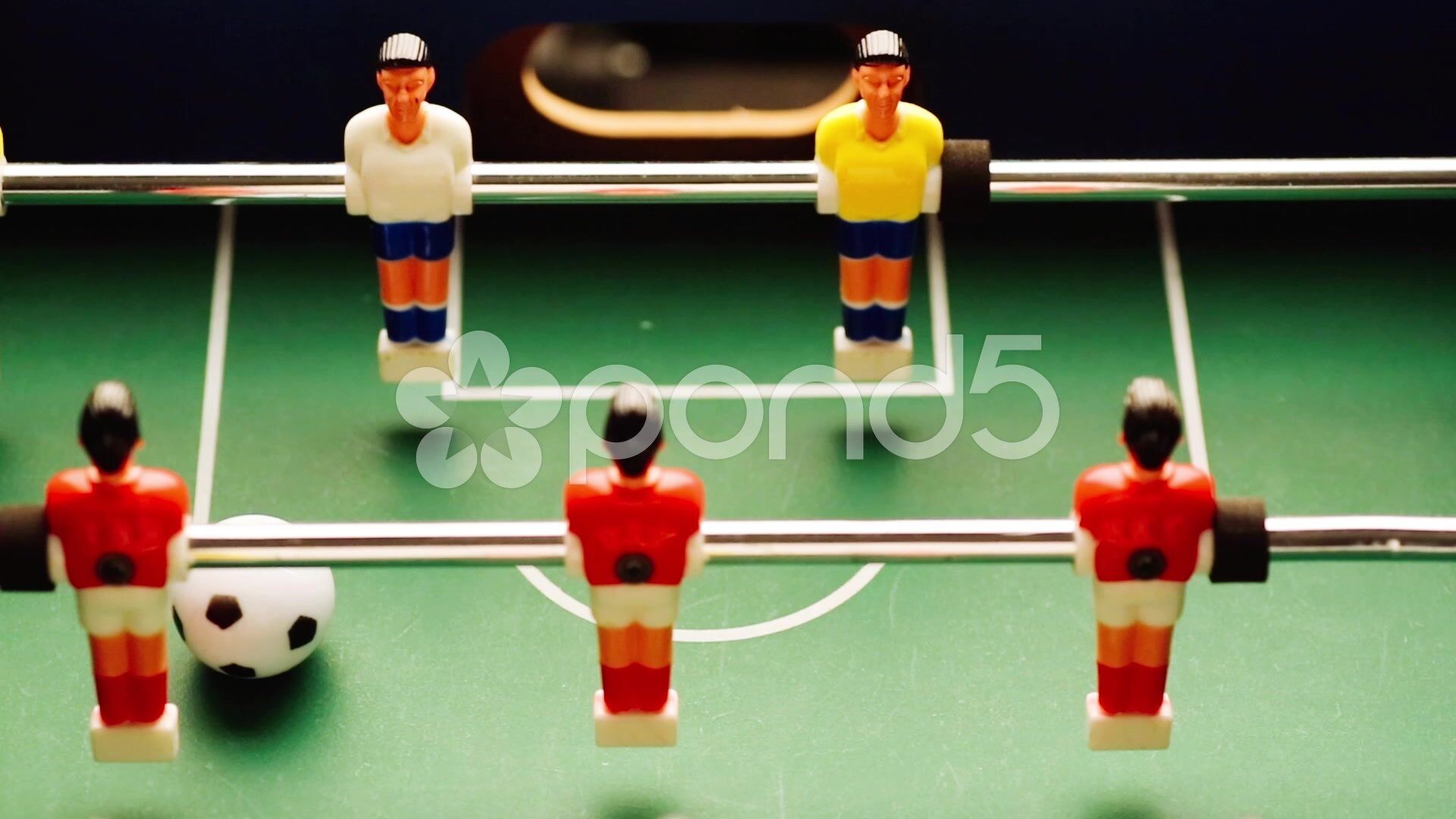 Una mesa de fútbol de mesa con figuras vestidas de rojo y amarillo.
