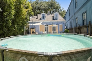 A swimming pool with a covered patio area and a house in the background. - Historic Governor's Home w/ Pool, Near French Quarter (New Orleans)