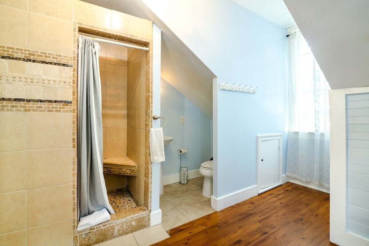 A bathroom with a shower, toilet, and sink.