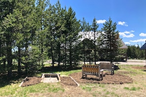 A park with a wooden bench, a small garden bed, and a building in the background.