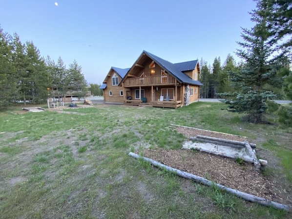 Escape to a serene log cabin surrounded by a lush garden and a peaceful atmosphere.
