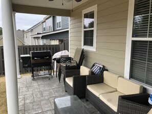Relax in a patio with comfortable seating and a barbecue grill.