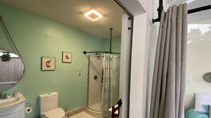 A bathroom with a toilet, sink, and shower.