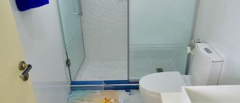Un baño con ducha de vidrio, inodoro blanco y bañera.