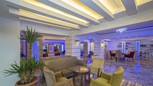 A spacious lobby with a seating area, a reception desk, and a chandelier. - TAC Premier Hotel - SPA (ALANYA)