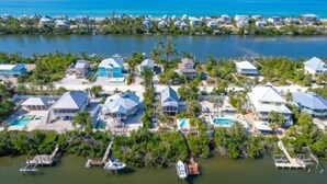 Vista aérea de una zona residencial costera con casas, un puerto deportivo y una gran masa de agua.