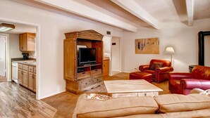 Ein Wohnzimmer mit einer Holz-Unterhaltungsanlage, roten Ledersofas und einem weißen Couchtisch.