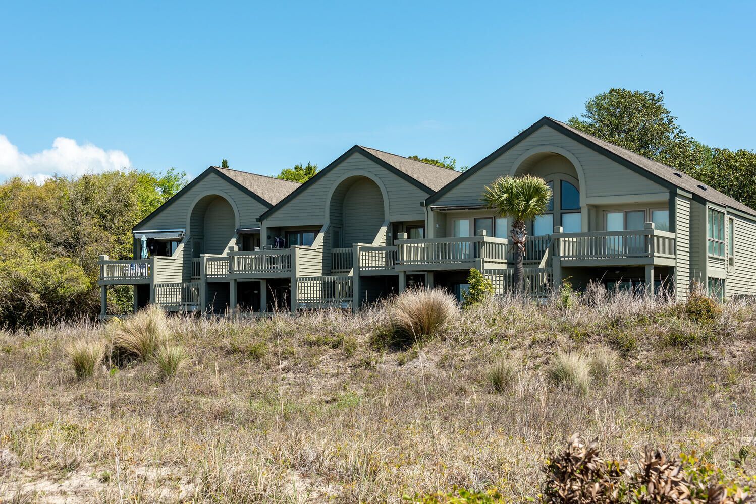 A beachfront property with multiple rooms featuring balconies and a pool area.