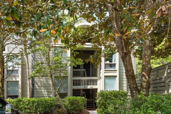 A two-story building with a balcony and a small porch.
