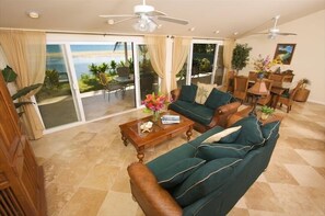 Relax in this stylish living room with a sliding glass door leading to a balcony overlooking the ocean.