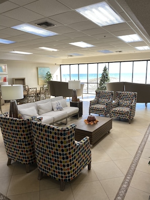 Relax in a stylish lounge area with a comfortable sofa set, armchairs, and a coffee table, offering a view of the beach.