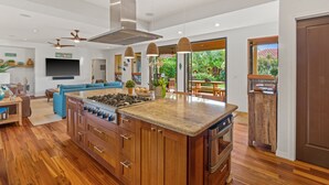 Une cuisine moderne avec des meubles en bois, un îlot central et un four encastré.