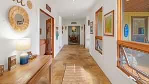 Un couloir avec un plancher en bois, un miroir et une pancarte sur laquelle on peut lire : « Vivez l’esprit Aloha ».