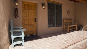 Une porte en bois, une fenêtre et un banc devant un b âtiment.