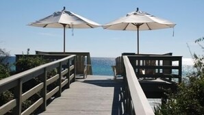 A wooden deck leading to a beach with two umbrellas. - Find The Best Seat at The Front Row / Quiet Area on St. Augustine Green in Rosemary / 4 Bikes (Panama City Beach)