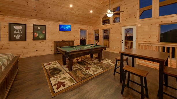 A wooden cabin with a pool table, a ceiling fan, and a television. - Otter Springs: Indoor Pool, Theater & Views (Sevierville)