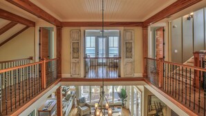 Un loft spazioso con soffitto alto, travi in legno e vista sul patio esterno.
