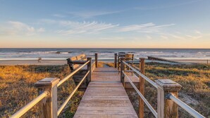 Una passerella di legno che conduce a una spiaggia con vista libera sull'oceano.