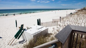 A beach with white sand, a wooden fence, and a clear blue sky. - Waters Edge 109 ~ Ground Floor and Beach Front ~ Steps to Pool and Sand! (Fort Walton Beach)