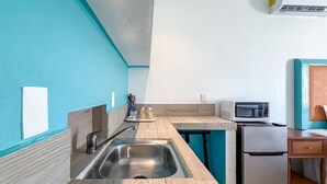 A kitchen with a sink, microwave, and refrigerator. - Beautiful studio just steps from Downtown (Isla Mujeres)
