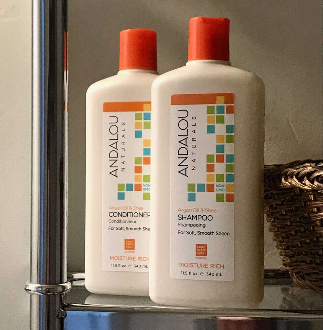 Dos botellas de acondicionador y champú Andalou Naturals sobre una estantería.