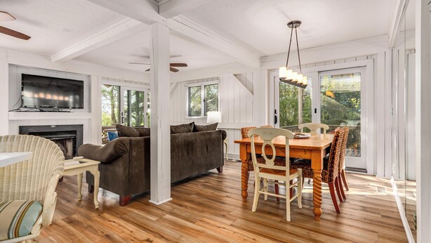 A spacious living area with a fireplace, sofa, dining table, and chairs. - Beautiful sunsets at this marsh view condo; enjoy the community pool close to all islands amenities (Bald Head Island)