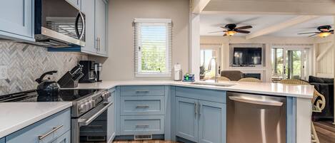 A modern kitchen with blue cabinets, a built-in oven, and a dishwasher.