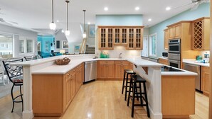 Una cucina moderna con mobili in legno, un'isola grande ed elettrodomestici in acciaio inossidabile.