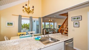 A modern kitchen with granite countertops, a stainless steel sink, and a built-in dishwasher.