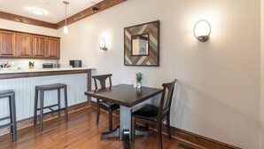Cocina moderna con armarios de madera, una isla central con taburetes e iluminación colgante.