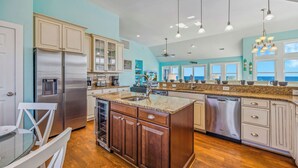 A modern kitchen with granite countertops, stainless steel appliances, and a view to the ocean. - Premier Oceanfront Dog Friendly w/ Pool, Hot Tub, Elevator, Theater and Game Rms (Rodanthe)