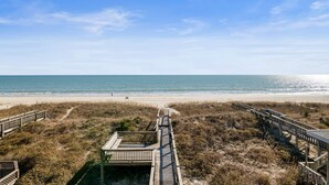Une plage avec des passerelles en bois menant au rivage.
