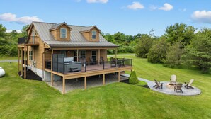 A two-story log cabin with a deck and outdoor seating area.