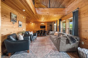A cabin interior with a wooden interior, a dining area, and a seating arrangement.