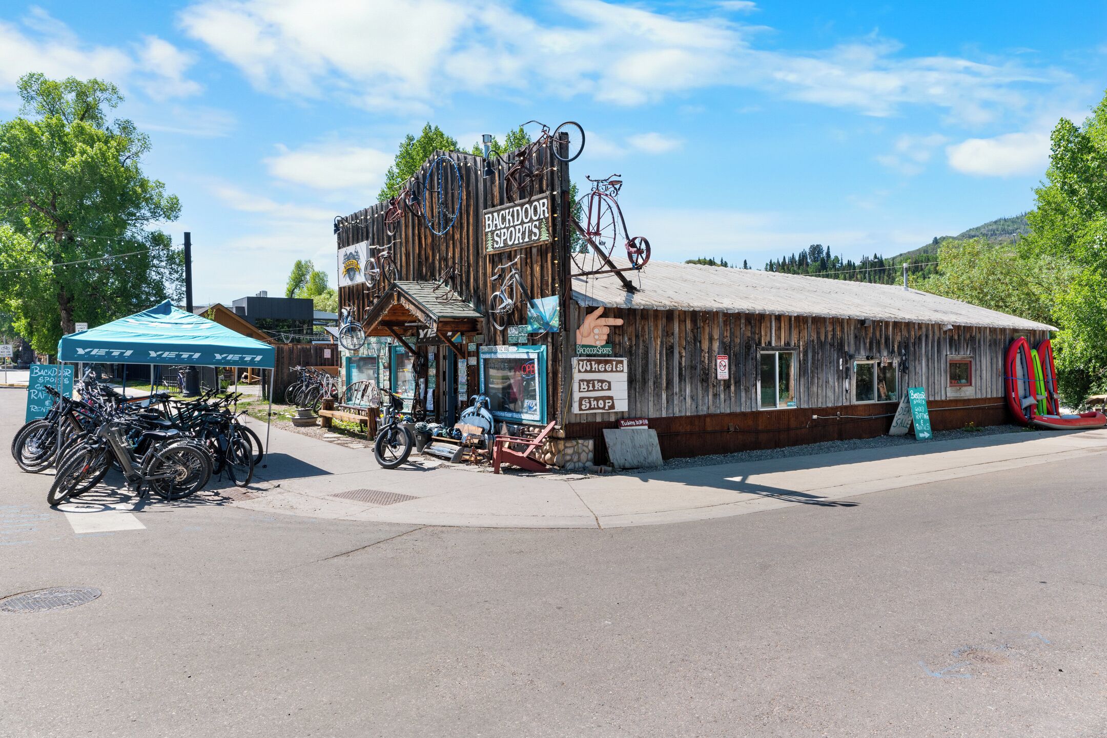 A rustic building with a sign reading "Backdoor Sports" and a bike shop.