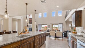 A spacious kitchen with a large island, wooden cabinets, and pendant lighting. - Paintbrush Retreat: Private Pool and Hot Tub, Movie Theater + Paradise Village W (Santa Clara)
