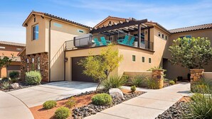A two-story house with a covered patio, a garage, and a landscaped front yard with various plants and a pathway. - Paintbrush Retreat: Private Pool and Hot Tub, Movie Theater + Paradise Village W (Santa Clara)