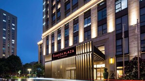 Un bâtiment moderne avec une enseigne bien visible indiquant « RAMADA PLAZA BY WYNDHAM ».