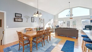 Un amplio salón con una mesa de comedor, sillas y un sofá.
