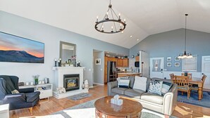 Un salón amplio con chimenea, zona de comedor y cocina.