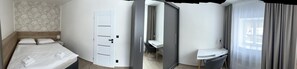Una habitación de hotel con cama, puerta, baño y zona de escritorio.