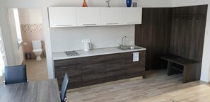 A modern kitchen with a built-in oven, a sink, and a coffee maker.
