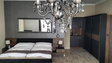 Ein modernes Schlafzimmer mit einem großen Bett, einer Chandelier, einem Schminktisch und einem Spiegel.