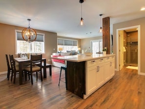 Enjoy cooking and dining in this well-equipped kitchen with a central island, oven, and stylish pendant lighting.