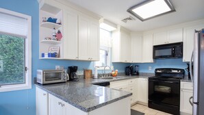A kitchen with white cabinets, a granite countertop, a black stove, a microwave, and a dishwasher. - Enjoy Family Memories - Great Outdoor Decks And Backyard; A Few Houses To Beach (Surf City)