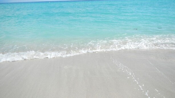 A beach with clear turquoise water and a sandy shore. - Beautiful/Spacious Ocean Reserve Sunny Isles Beach #STR-02481 (Sunny Isles Beach)