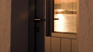 A door with a view of the sunset over water.