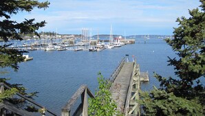 A harbor with boats, a wooden pier, and a clear sky. - Enjoy the stunning ocean view from the hot tub at Port! (Southwest Harbor)