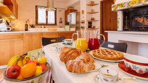A breakfast table with croissants, fruits, a pie, and a jug of juice. - Villa ' Pian del Rocchio ' - Beautiful Country House in a lush Umbria plateau (San Venanzo (TR))